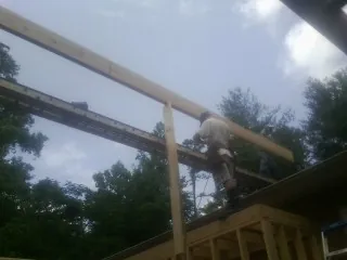 Carpenter setting a ridge beam over a new addition frame — Ice Dam Removal by Roofing Brothers in Ballwin